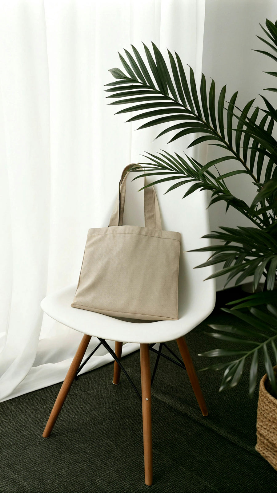 Tote de sport en toile taupe posé sur une chaise blanche dans une lumière douce